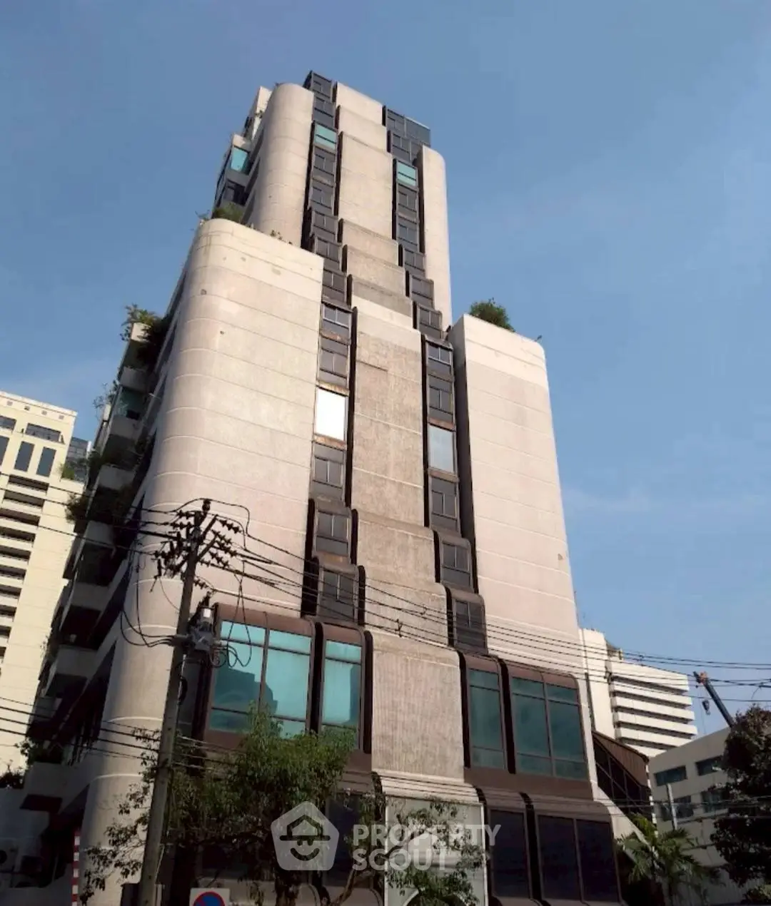 Modern high-rise building with unique architectural design and urban surroundings.