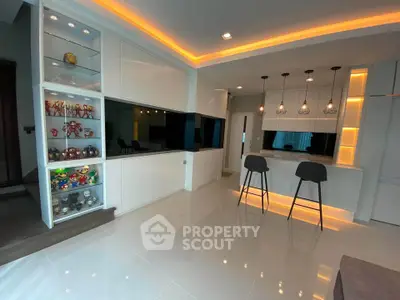 Modern living room with sleek design and stylish lighting, featuring a cozy bar area and display shelves.