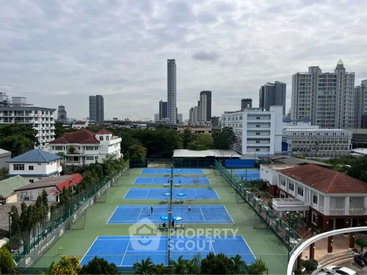 Stunning cityscape view with tennis courts and high-rise buildings