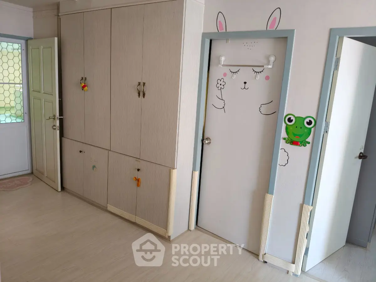 Charming children's room with playful wall art and ample storage space.