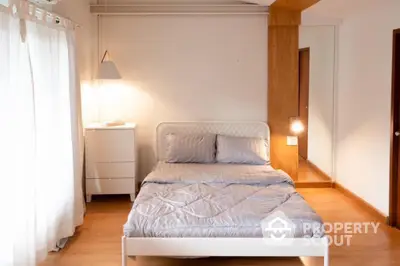 Cozy minimalist bedroom with natural light and wooden flooring