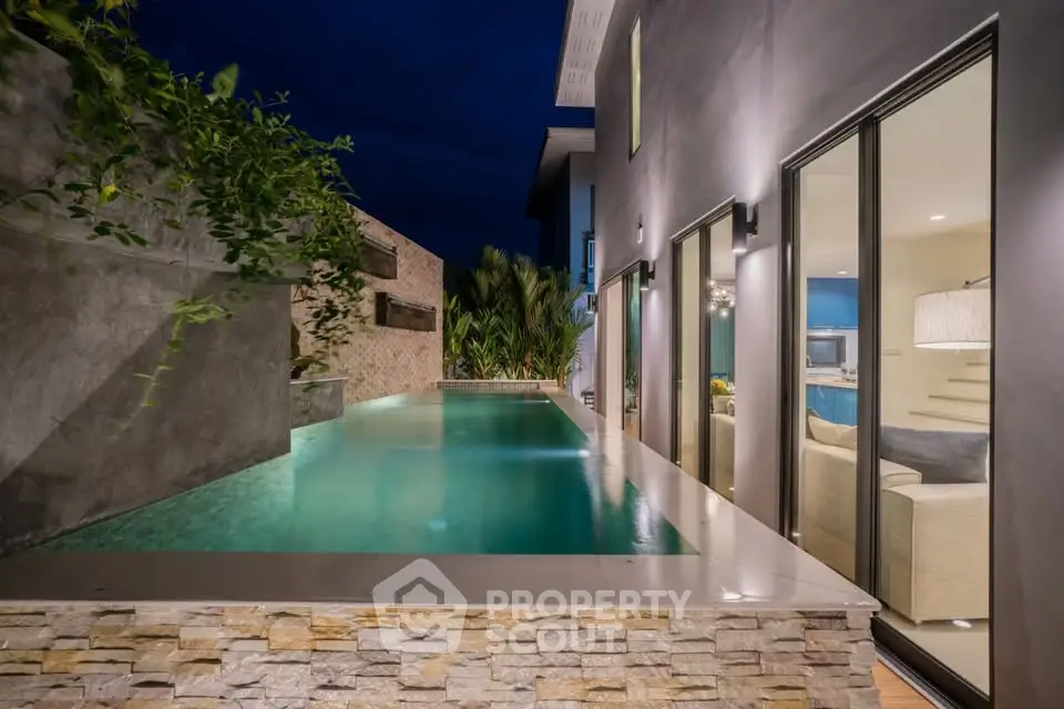 Luxurious modern home with stunning private pool and elegant interior view at night.