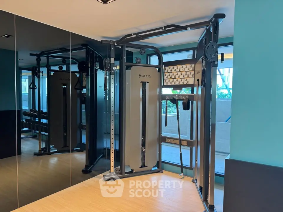 Modern gym with state-of-the-art fitness equipment and mirrored walls in a luxury residential building.