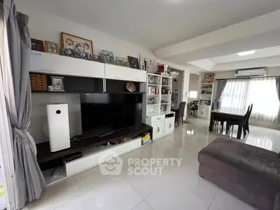 Spacious living room with modern entertainment center and dining area