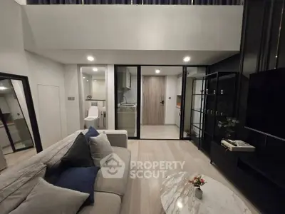Modern living room with sleek design and open layout, featuring a cozy sofa and stylish decor.