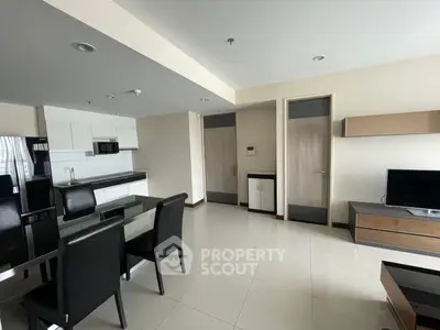 Modern open-layout living room with sleek furniture and integrated kitchen area, perfect for contemporary living.