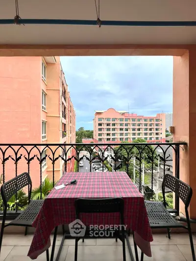 Charming balcony with table and chairs offering a scenic urban view, perfect for relaxation.