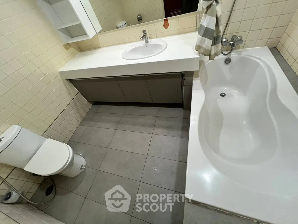 Modern bathroom with sleek fixtures and spacious bathtub in a contemporary home.