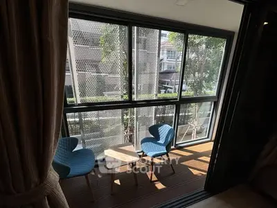 Charming balcony with modern seating and lush garden view, perfect for relaxation.