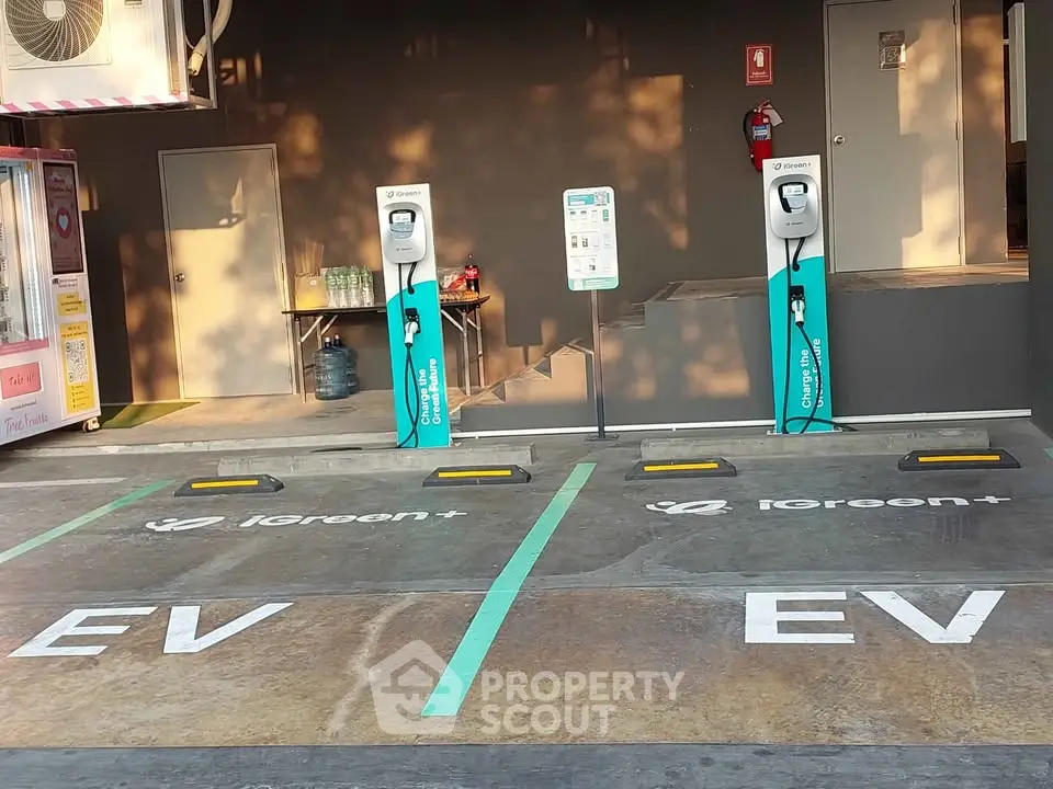 Modern electric vehicle charging station with two charging points in a well-lit parking area.
