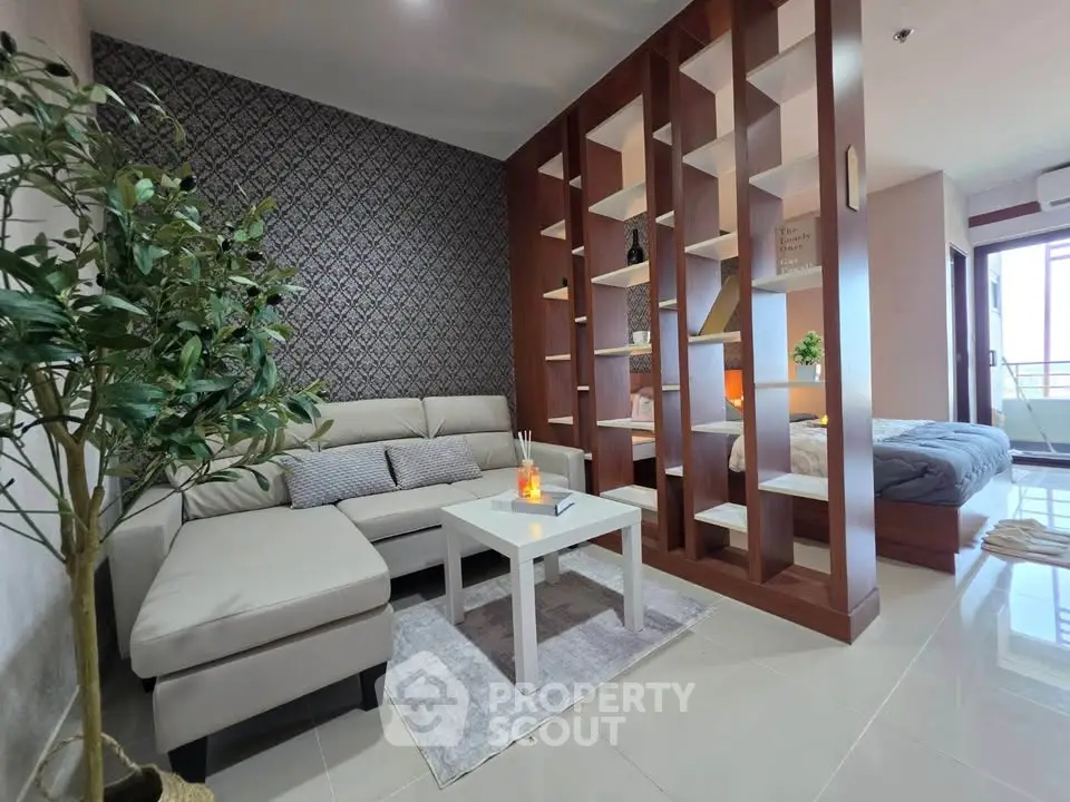 Modern living room with stylish partition and cozy seating area in open-plan apartment.