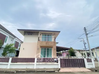 Modern two-story house with spacious yard and gated entrance in suburban neighborhood.