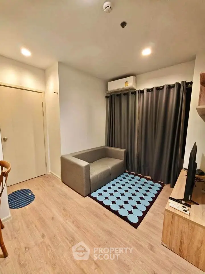 Cozy living room with modern decor and natural light, featuring a stylish sofa and entertainment setup.