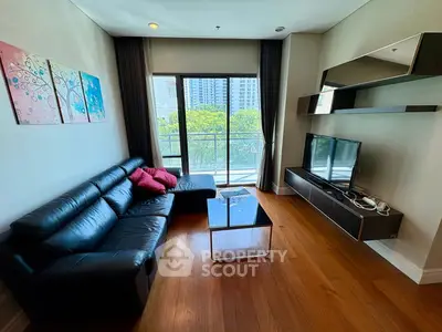 Modern living room with sleek black leather sofa and large window view