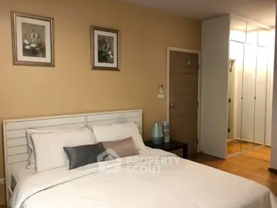 Cozy bedroom with modern decor and mirrored wardrobe in stylish apartment.