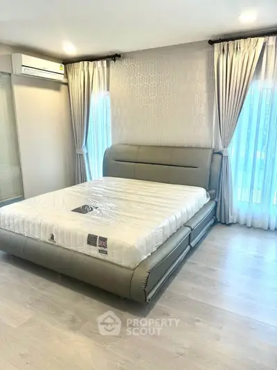 Modern bedroom with stylish decor and large windows for natural light