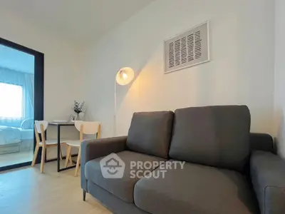 Modern living room with cozy sofa and dining area in bright apartment.