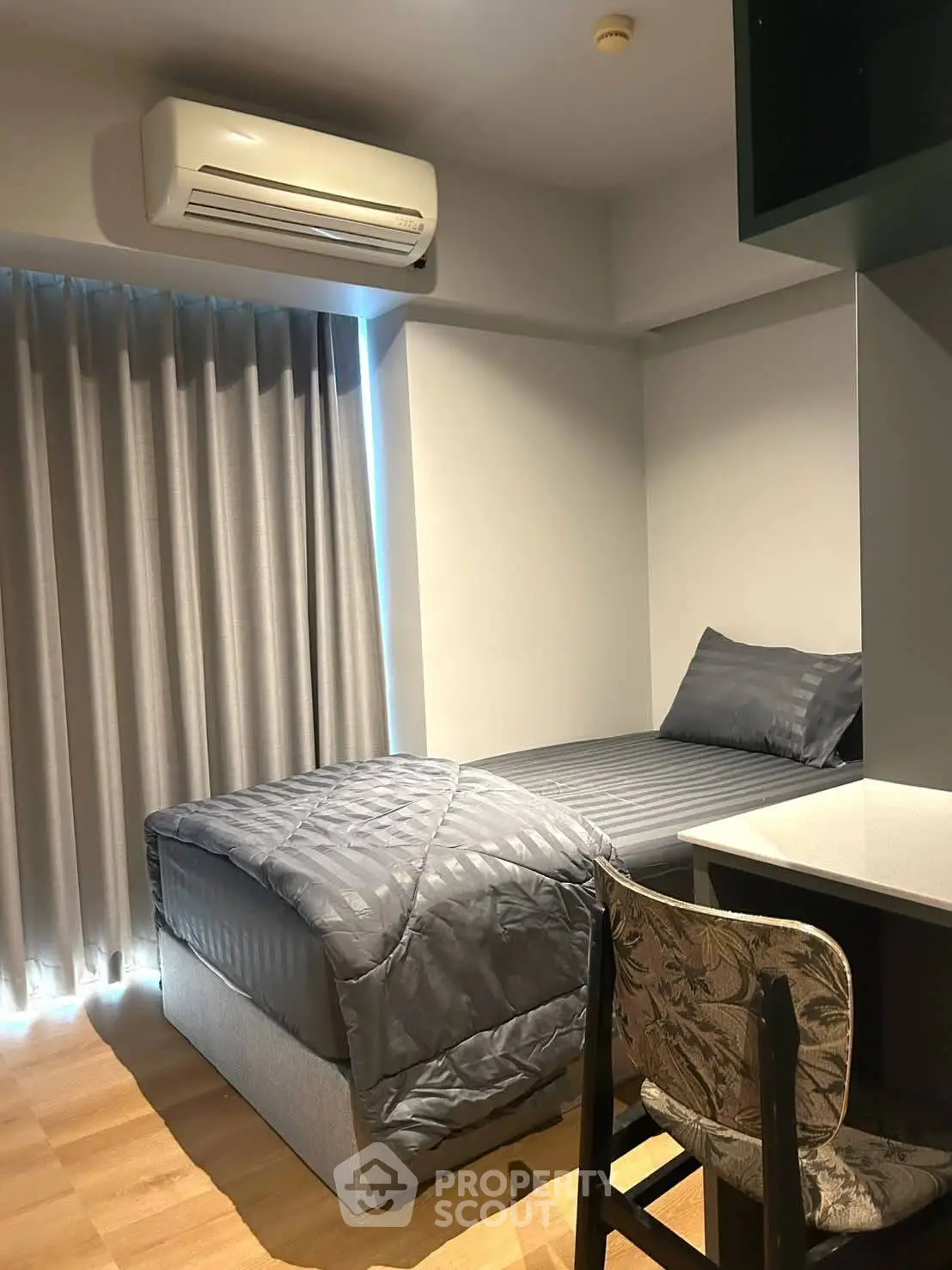 Cozy bedroom with modern decor and air conditioning, perfect for comfortable living.