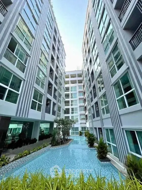 Modern condominium with pool view and lush greenery, perfect for urban living.
