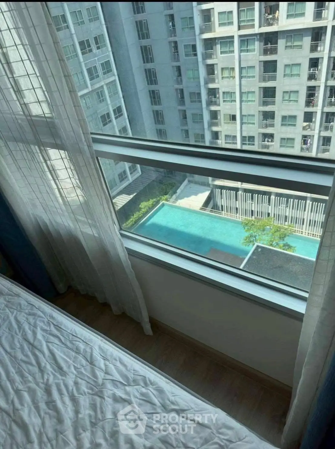 Stunning high-rise apartment view with pool and cityscape, perfect for urban living.