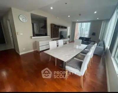 Spacious modern living room with dining area and city view, featuring elegant wooden flooring.