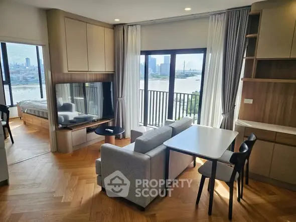 Modern living room with river view, open layout, and stylish furniture in a high-rise apartment.