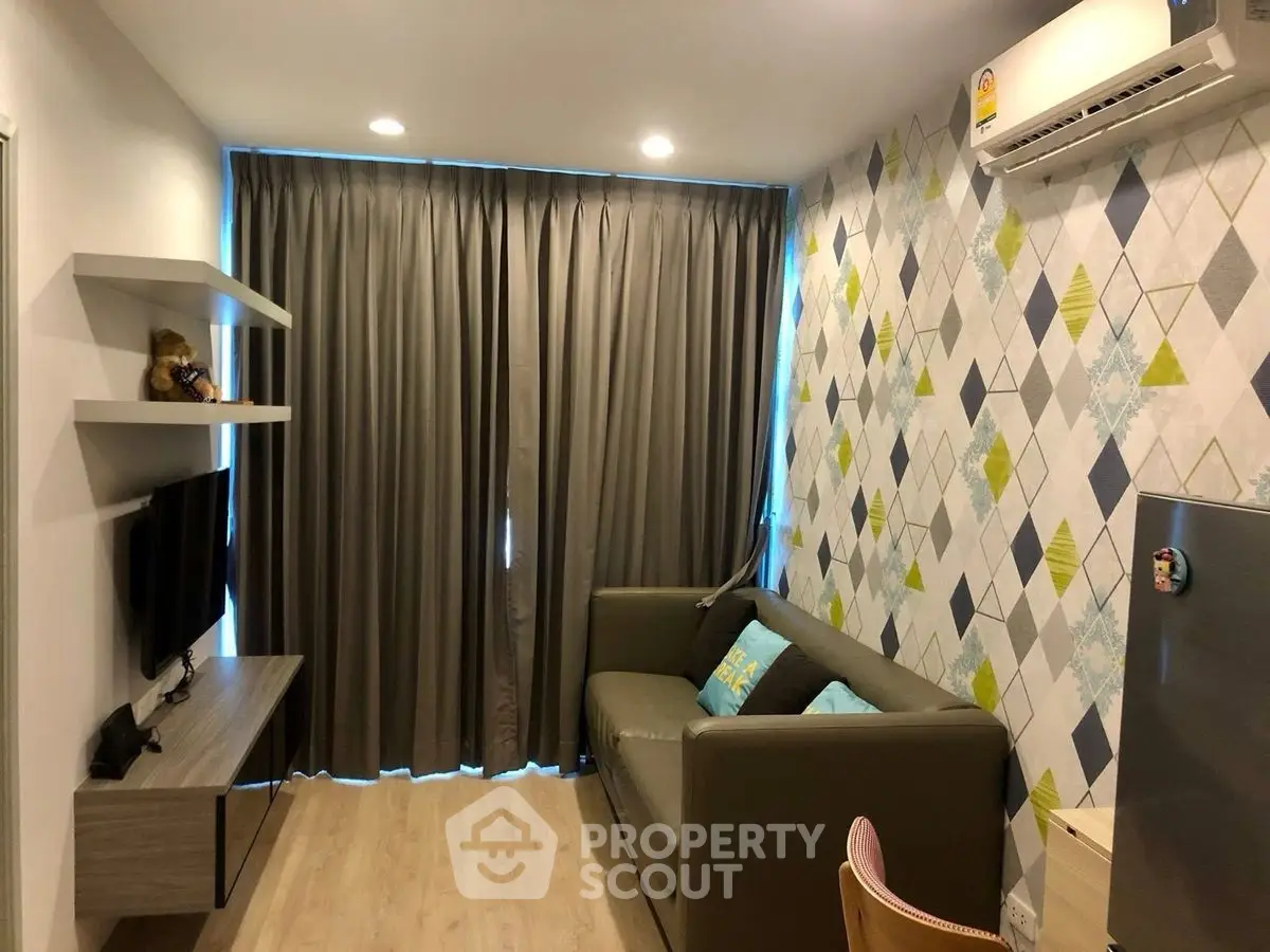 Modern living room with stylish decor and air conditioning, featuring a cozy sofa and wall-mounted TV.