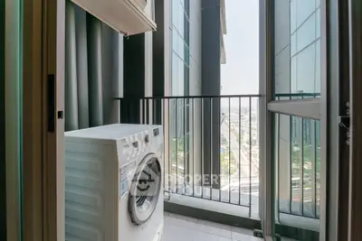 Modern high-rise balcony with washing machine and city view, perfect for urban living.