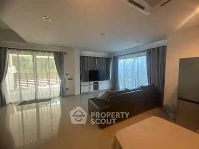 Spacious living room with modern decor and large windows for natural light