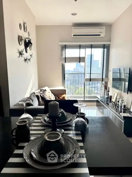 Modern living room with stylish decor and city view from balcony.
