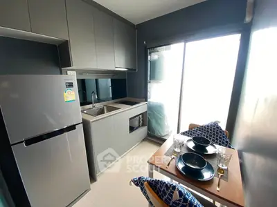 Modern kitchen with sleek cabinetry and dining area in stylish apartment