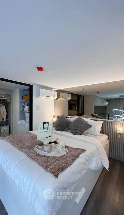 Modern bedroom with cozy decor and stylish lighting, featuring a comfortable bed and open closet.