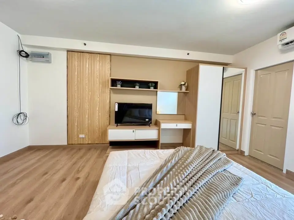 Modern bedroom with stylish wooden flooring and built-in storage solutions