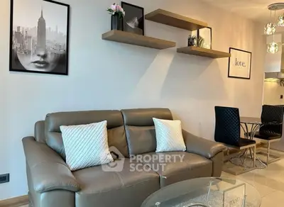 Modern living room with leather sofa, stylish wall art, and elegant dining area.