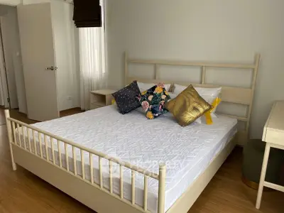 Spacious bedroom with stylish decor and natural light, featuring a comfortable bed and elegant furnishings.