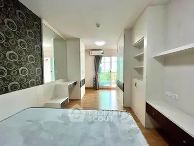 Modern bedroom with stylish decor and balcony access in a contemporary apartment.