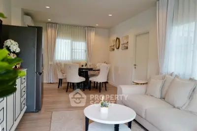Elegant living room with modern decor and dining area, featuring neutral tones and stylish furnishings.