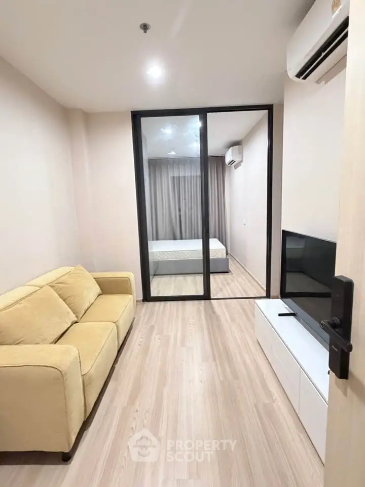 Modern apartment with cozy living room and bedroom, featuring sleek design and neutral tones.