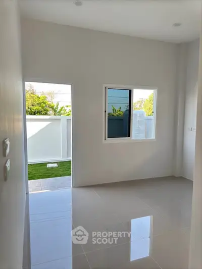 Bright empty room with glossy tiled floor and garden view