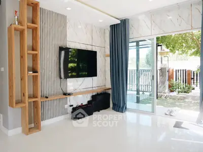 Modern living room with TV and large sliding glass doors to garden view