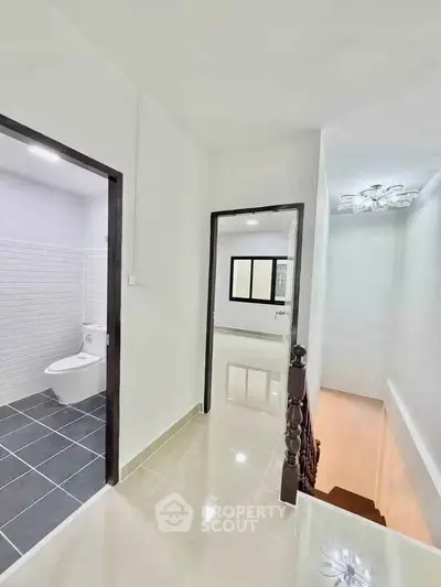 Bright hallway with modern bathroom and staircase in contemporary home.