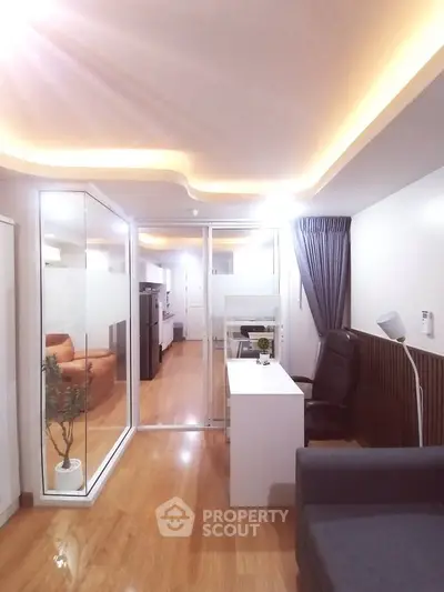 Modern apartment interior with sleek design and ambient lighting, featuring a glass partition and stylish furnishings.