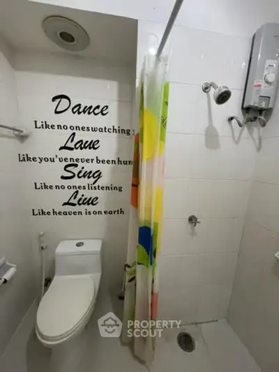 Cozy bathroom with motivational wall quote, featuring shower, toilet, and water heater.