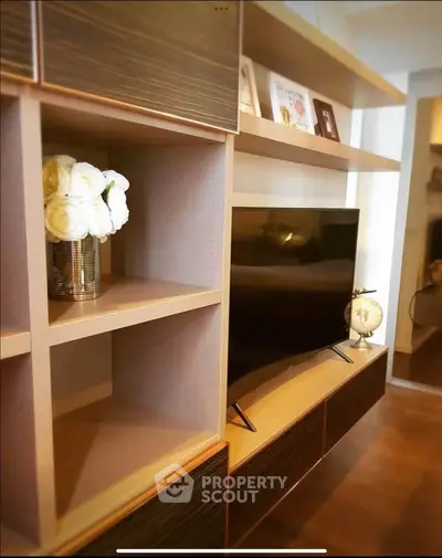 Modern living room with sleek shelving and flat-screen TV, perfect for stylish urban living.