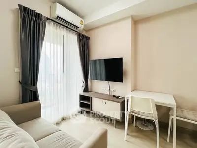 Modern living room with sleek furniture and natural light from large window.