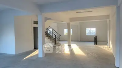 Spacious open-plan interior with natural light and modern staircase, ideal for customization.