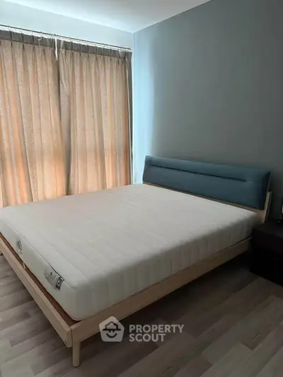 Spacious bedroom with modern bed and natural light from large windows.