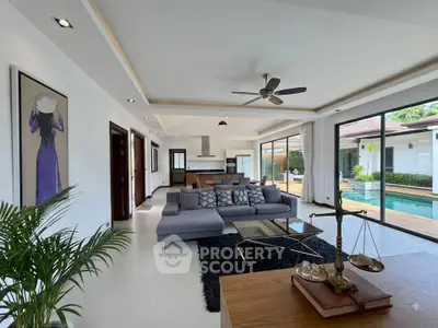 Luxurious open-plan living room with pool view, modern decor, and elegant furnishings in a contemporary home.