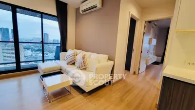 Modern living room with city view, stylish furniture, and wooden flooring in a high-rise apartment.