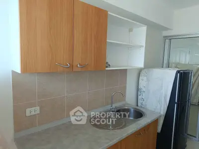 Compact kitchen with wooden cabinets and stainless steel sink